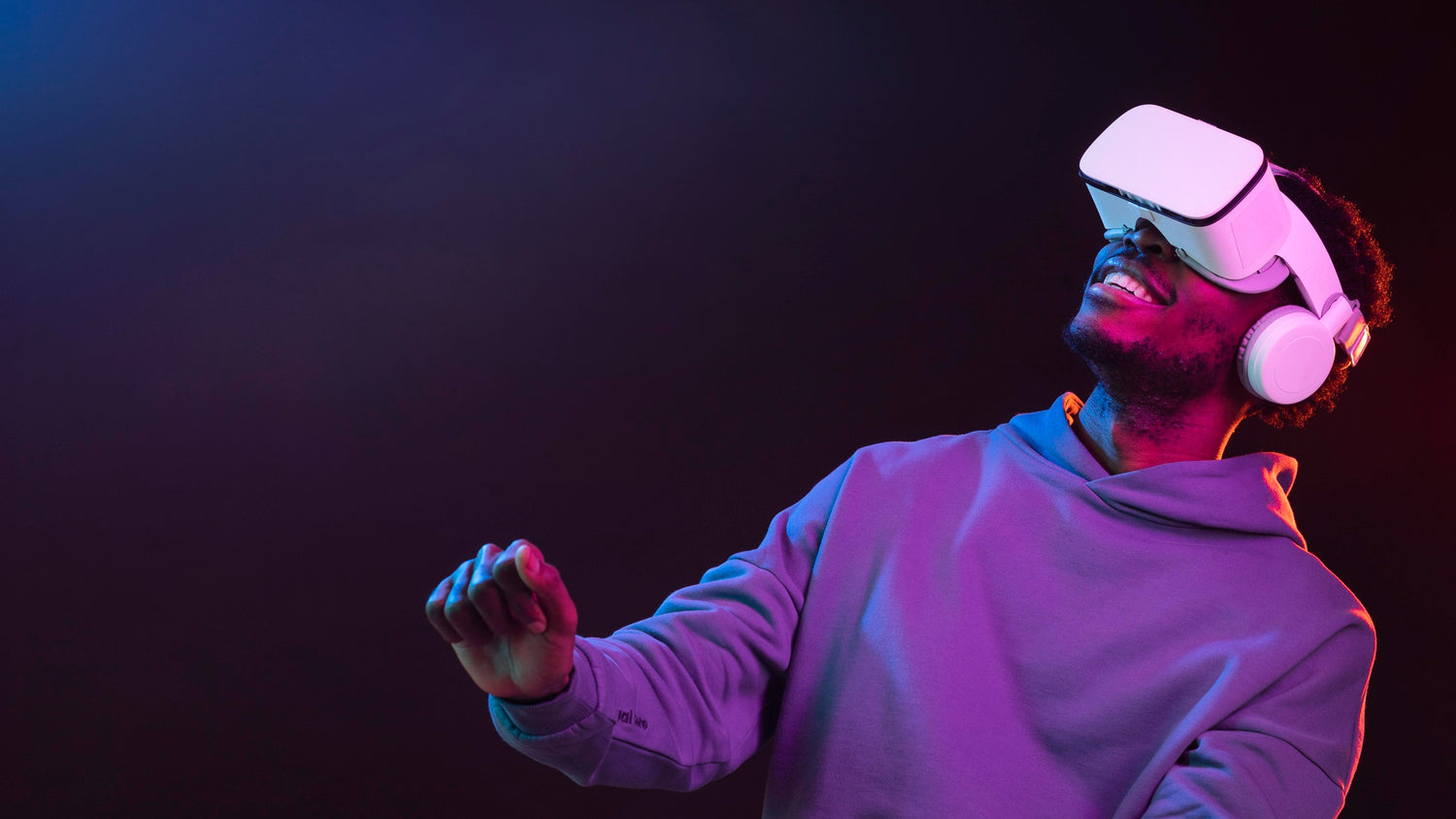 Person wearing a VR headset in a dark room with colorful lighting