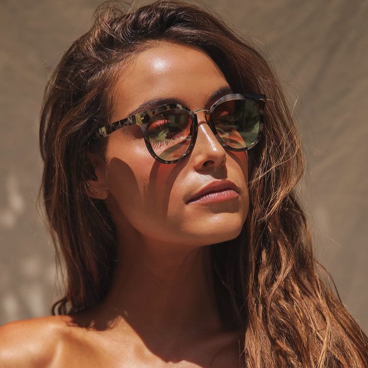 Woman wearing sunglasses with a neutral background